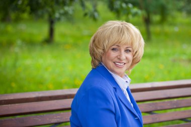 Portrait of an elderly beautiful woman in blue jacket