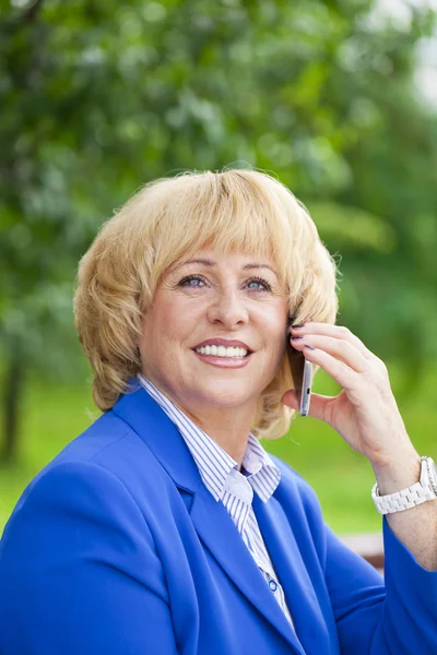 Retrato de uma mulher bonita idosa falando em um telefone celular — Fotografia de Stock