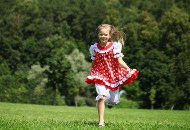 Kırmızı benekli sundress üzerinde büyük bir çalışma içine, küçük kız 