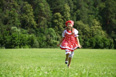 Kırmızı benekli sundress üzerinde büyük bir çalışma içine, küçük kız 