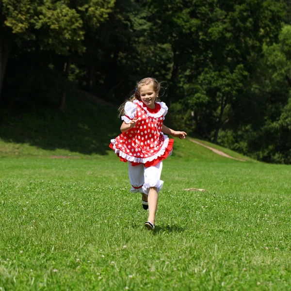 Kırmızı benekli sundress üzerinde büyük bir çalışma içine, küçük kız — Stok fotoğraf