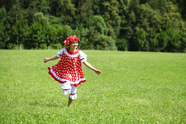 Kırmızı benekli sundress üzerinde büyük bir çalışma içine, küçük kız — Stok fotoğraf