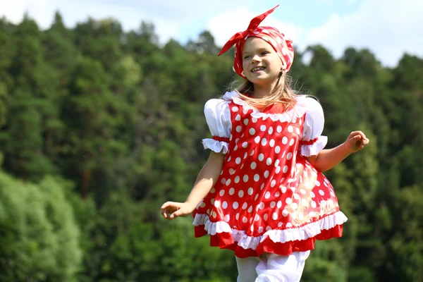 Ragazzina in un abito da sole a pois rosso in una grande corsa sul — Foto Stock