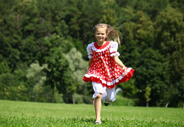 Menina em um vestido vermelho polka-dot em uma grande corrida no — Fotografia de Stock