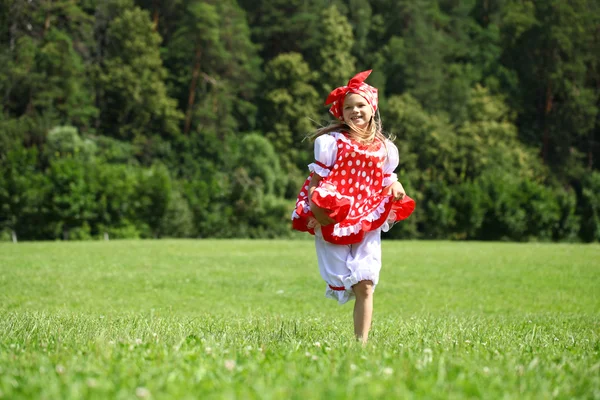 Маленька дівчинка в червоному сонечку в головному бігу на — стокове фото