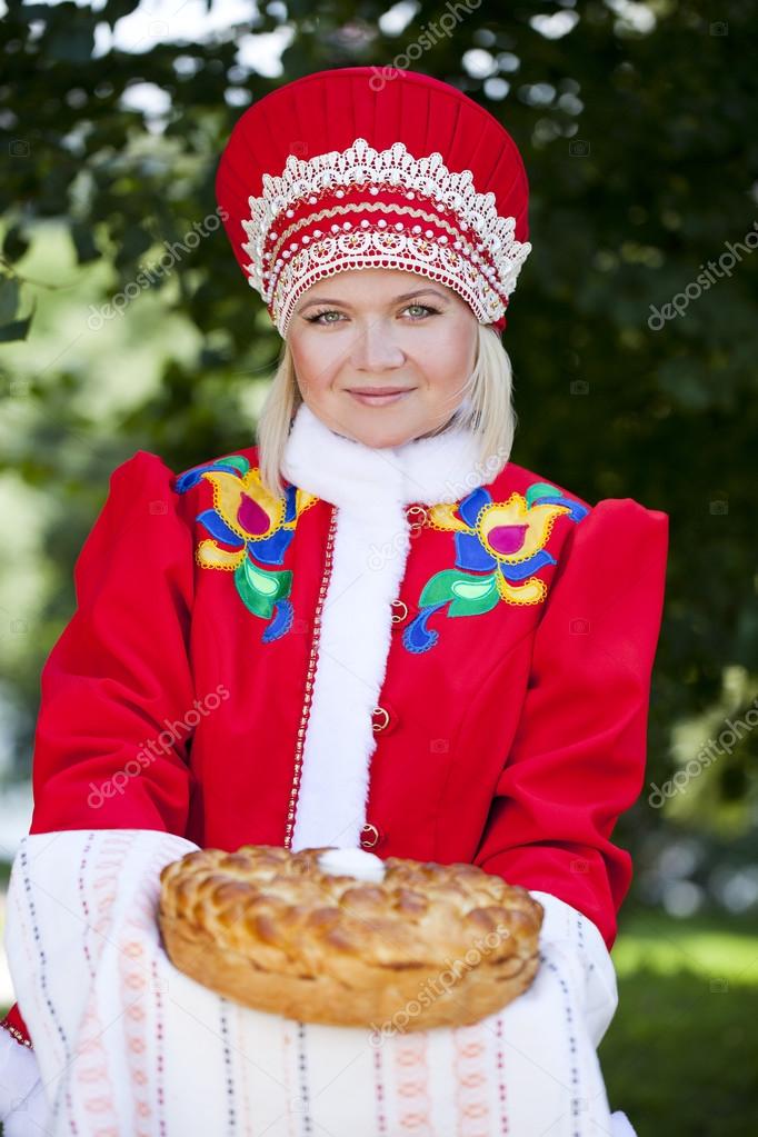 Young woman is dressed in the Russian national dress in summer p