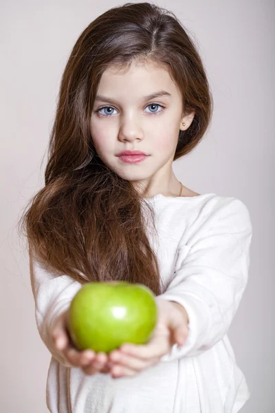 Portrait of a beautiful little girl holding a green apple — Stock Photo, Image