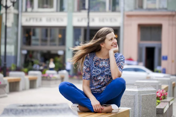 Jovem mulher bonita feliz senta-se em um banco — Fotografia de Stock