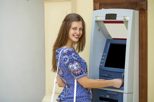 Jovencita sonriente retirando dinero del cajero automático — Foto de Stock