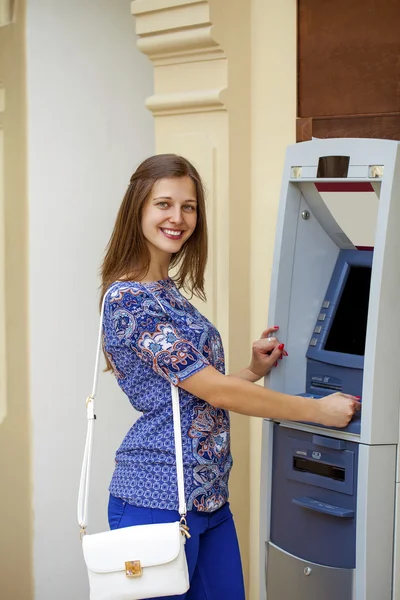 Jovencita sonriente retirando dinero del cajero automático —  Fotos de Stock