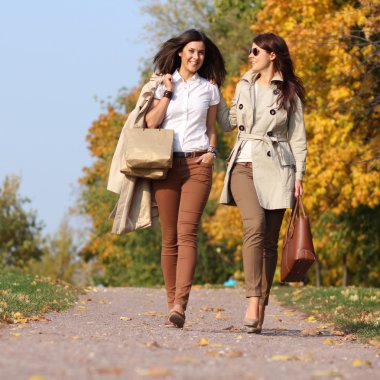 Sonbahar akçaağaç yaprakları sonbaharda ou Park ile iki çekici kadın