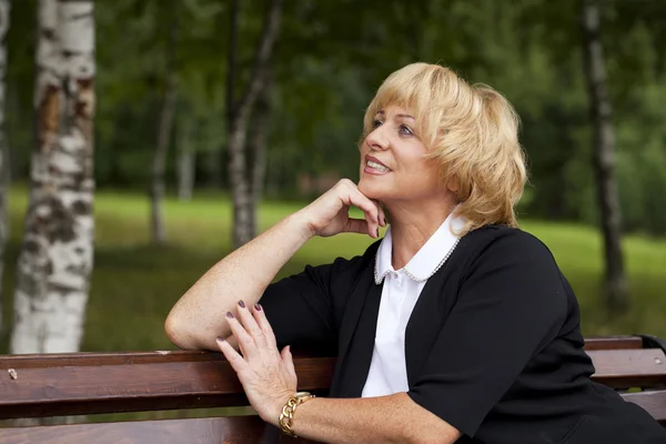 Portrait of serene mature woman in the summer park — Stock Photo, Image