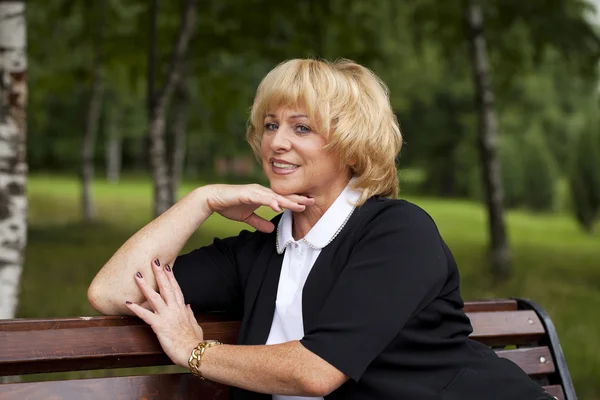 Portrait of serene mature woman in the summer park — Stock Photo, Image