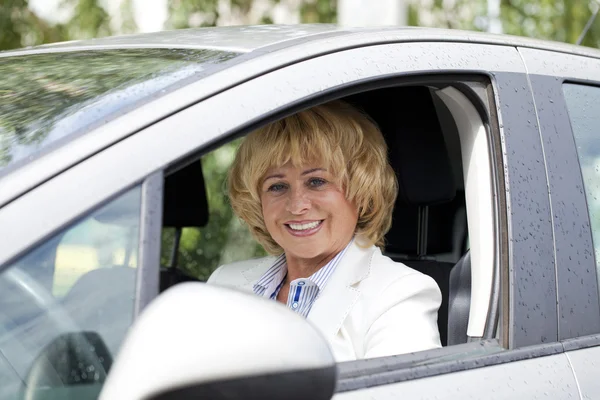 Viejo feliz anciano conductor mujer 55-60 años en chaqueta Conducción de una C — Foto de Stock