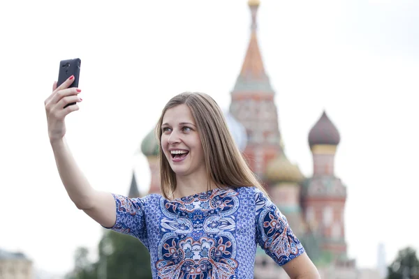 Gelukkig mooi meisje gefotografeerd op een mobiele telefoon — Stockfoto