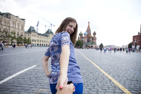 Young happy girl pulls the guys hand on the Red Square in Moscow — Stock Photo, Image
