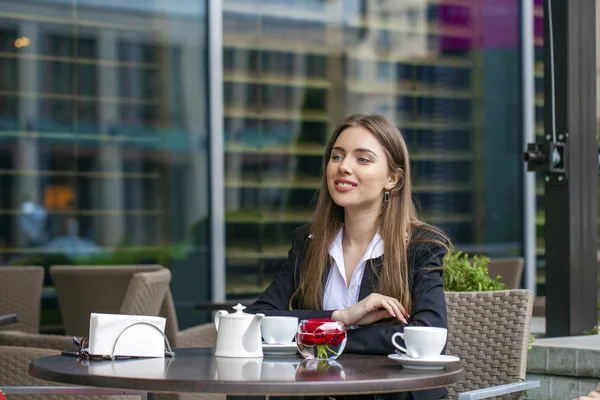 Счастливая деловая женщина, выпившая чашку кофе в летнем кафе — стоковое фото