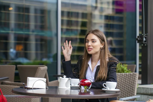 Felice donna d'affari a bere una tazza di caffè in un caffè estivo — Foto Stock