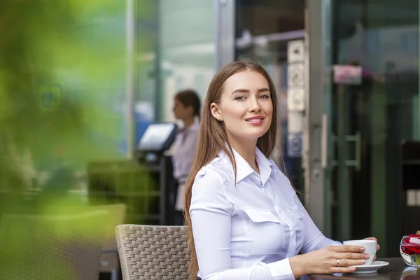 Mujer de negocios feliz en camisa blanca bebiendo una taza de café en —  Fotos de Stock