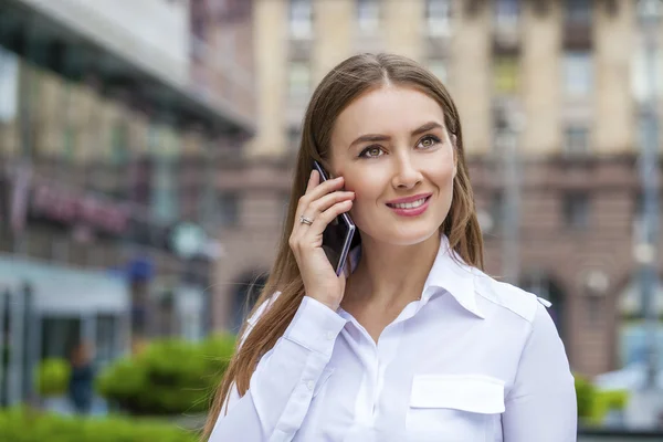 Mulher de negócios feliz em camisa branca chamando por telefone — Fotografia de Stock