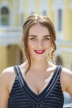 Poz açık havada içinde güneşli biz siyah elbiseli genç güzel kadın