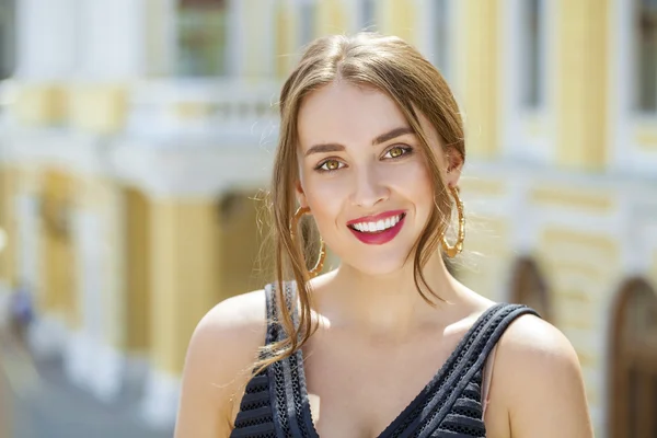 Jeune belle femme en robe noire posant en plein air sous le soleil nous — Photo