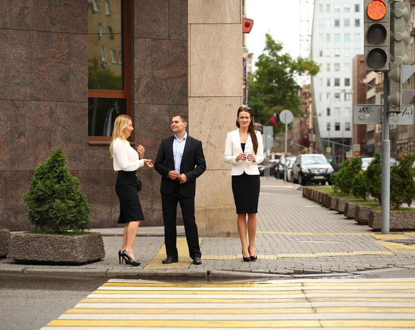 Молодой бизнесмен идет по улице со своими секретаршами — стоковое фото