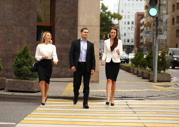 Un joven empresario caminando por la calle con sus secretarias — Foto de Stock