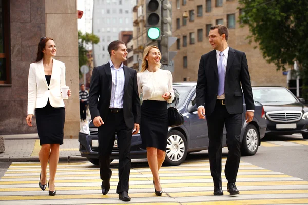 Четверо успешных бизнесменов переходят улицу в городе — стоковое фото