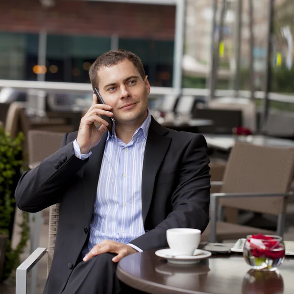 Jovem empresário alegre chamando por telefone — Fotografia de Stock