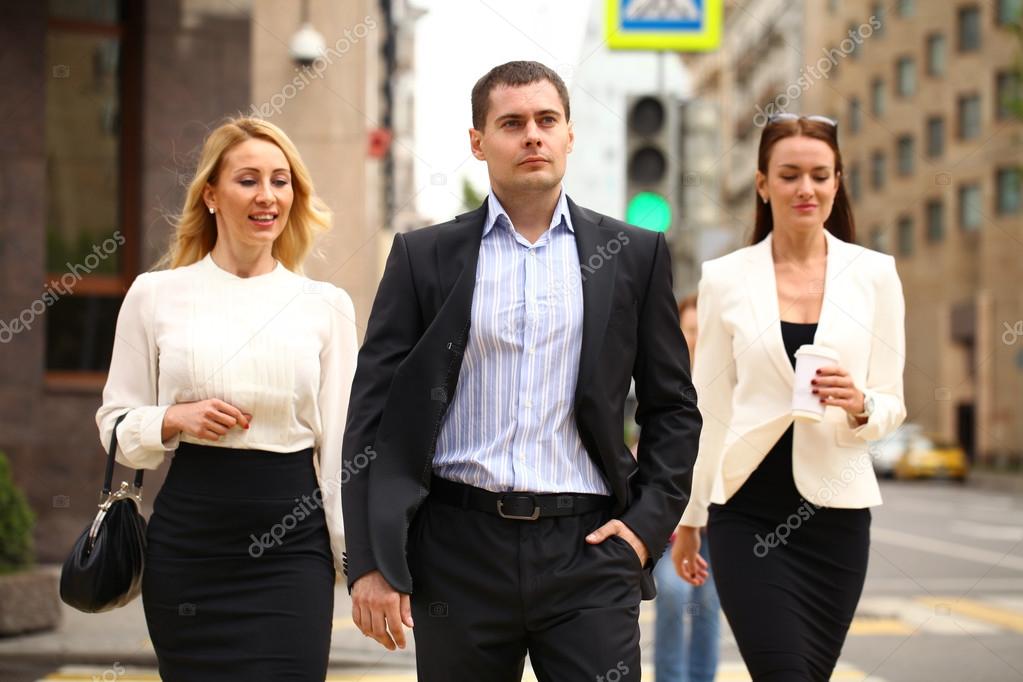 A young businessman walking on the street with their secretaries