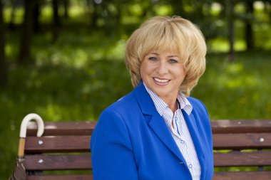 Portrait of an elderly beautiful woman in blue jacket