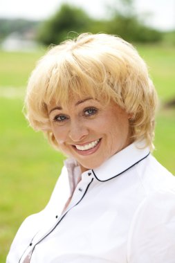 Arka plan üzerinde beyaz bir ceketi giyen yaşlı bir kadın portresi