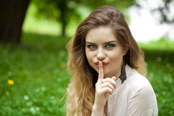 Sarışın kadın işaret parmağı dudaklar için sessizlik işareti olarak koymuştur — Stok fotoğraf