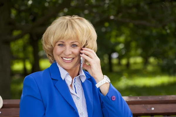 Porträtt av en äldre vacker kvinna talar i en mobiltelefon — Stockfoto