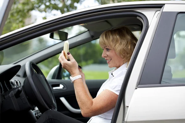 Oude gelukkig oudere stuurprogramma vrouw 55-60 jaar in jas rijden een C — Stockfoto