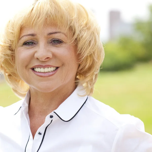 Porträt einer älteren Frau in weißer Jacke auf dem Hintergrund — Stockfoto