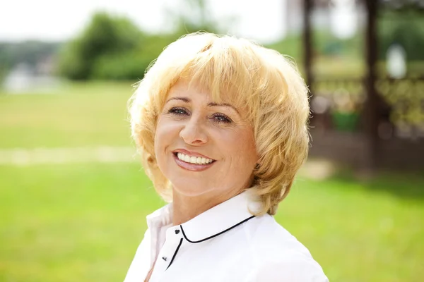 Portrait of an elderly woman in a white jacket on the background — Stock Photo, Image