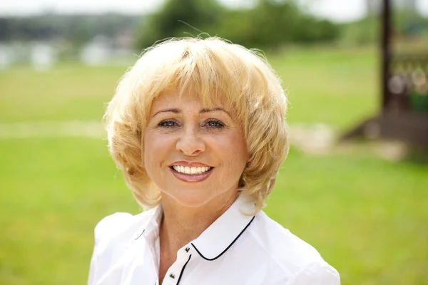 Portrait of an elderly woman in a white jacket on the background — Stock Photo, Image