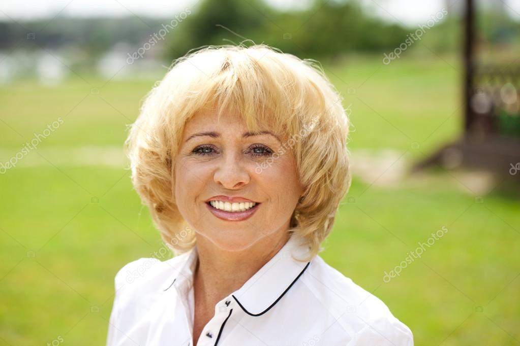 Portrait of an elderly woman in a white jacket on the background