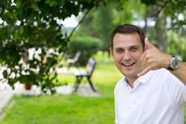 Happy brunette men making a call me gesture