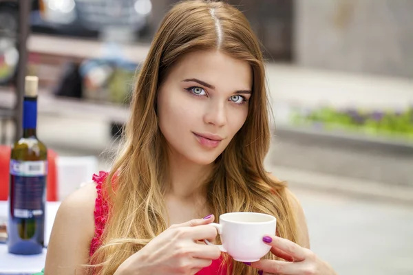 Mladá krásná světlovlasá žena, sedící v letní restauraci — Stock fotografie