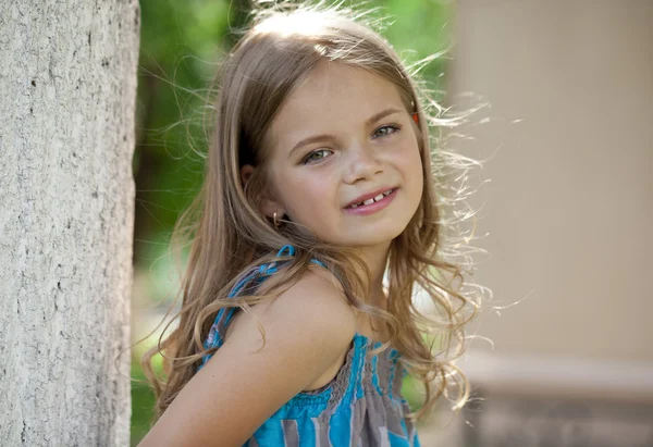 Retrato de cerca de una niña de siete años, contra el fondo —  Fotos de Stock