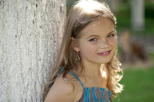 Retrato de cerca de una niña de siete años, contra el fondo —  Fotos de Stock