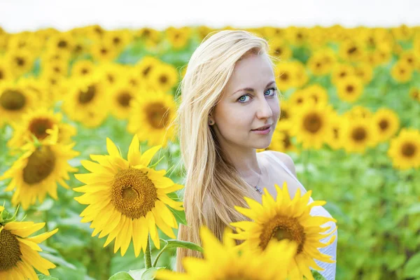 Porträtt av en vacker ung blond kvinna i en vit klänning på en — Stockfoto