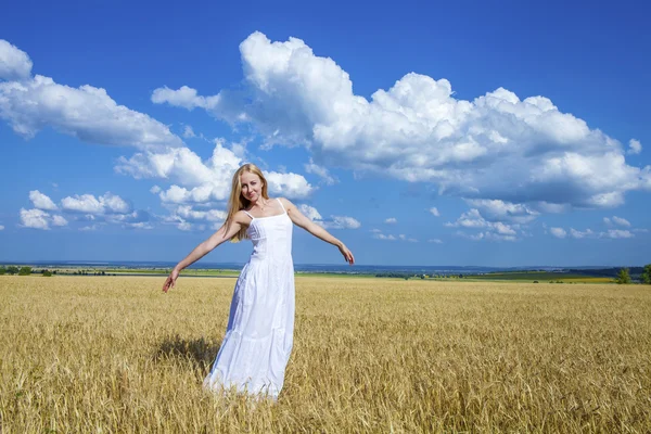 Mulher bonita nova em um vestido branco longo está de pé em um whe — Fotografia de Stock