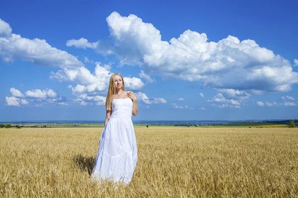 Young beautiful woman in a long white dress is standing in a whe Stock Photo