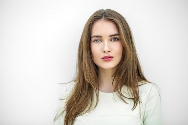 Güzel genç mutlu kadın beyaz bir duvara poz