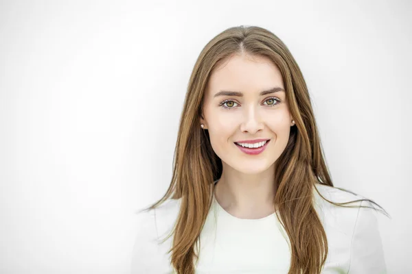 stock image Beautiful young happy woman posing against a white wall