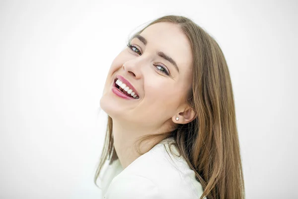 Mulher feliz bonita jovem posando contra uma parede branca — Fotografia de Stock